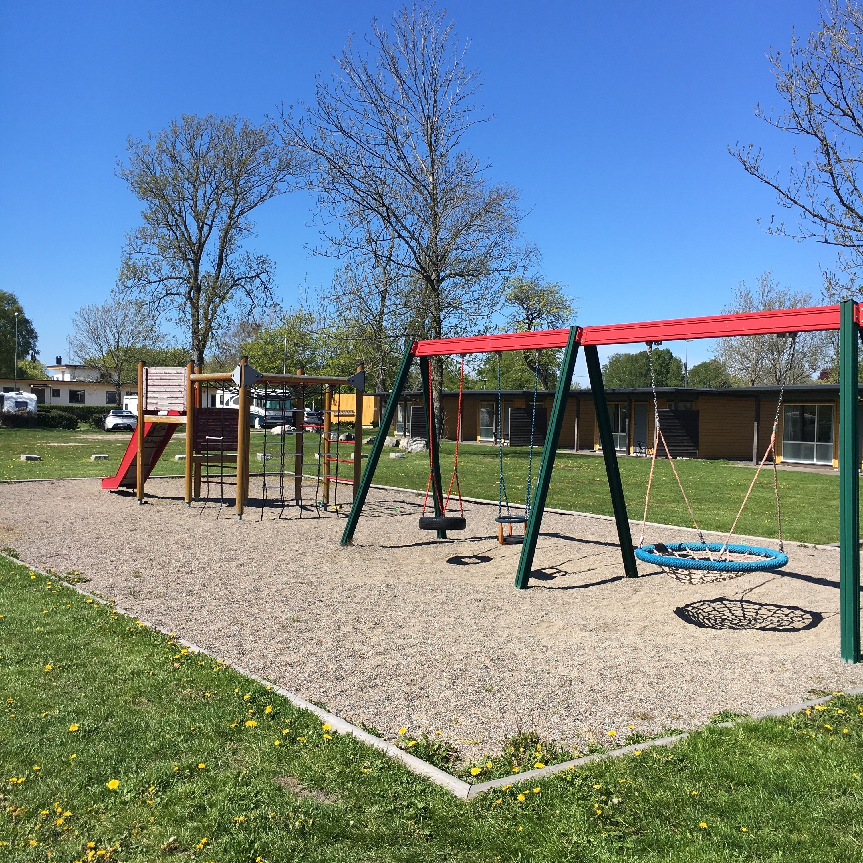 A playground with swings, a slide, and a climbing structure.