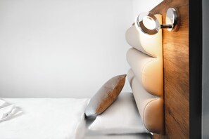 A bed with a wooden headboard and a light fixture.