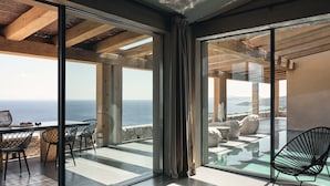 A modern interior with large glass doors leading to a terrace with a view of the sea. - Vais luxury villas (Zakynthos)