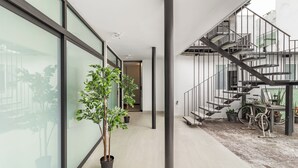 A modern interior with a staircase, potted plants, and a bicycle. - Singular Goldsmith (Mexico City)