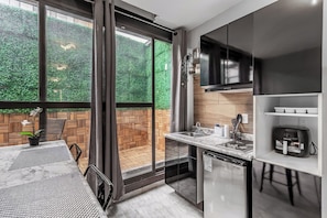 A modern kitchen with a large window, a built-in oven, and a coffee machine. - Singular Goldsmith (Mexico City)