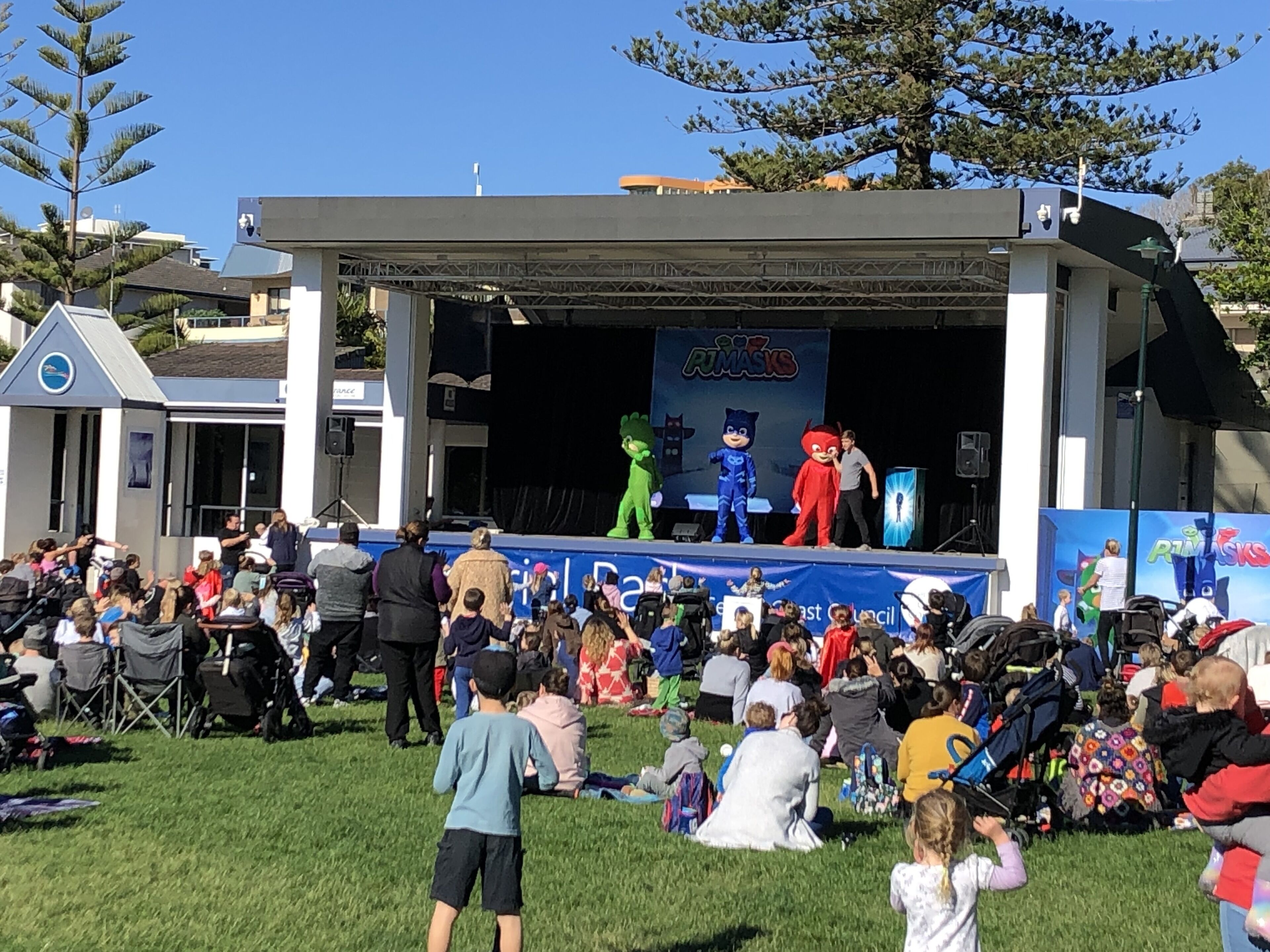 A stage with a blue banner and a group of people gathered in front.