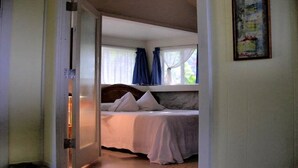 Quarto com cama, cortinas e janela.