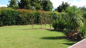 Une pelouse bien entretenue, agrémentée de jeunes arbres et d’une variété d’arbustes.