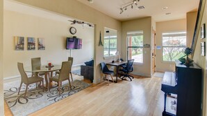 A spacious living area with a dining table, chairs, a sofa, a piano, and a large window providing natural light. - Whole Home Air Cleaner, Quiet surroundings, deck and Jacuzzi, near golf course (Austin)