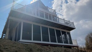 A two-story building with a balcony on the upper level. - Breathtaking Remote Oceanfront Oasis Panoramic Clifftop Views (Lubec)