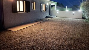A building with a gravel driveway, a front door, and windows with shutters. - Comfortable villa with heated pool and spa between sea and mountains (Aléria)