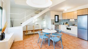 A modern kitchen with a dining area, featuring a staircase, white cabinetry, and a stainless steel refrigerator. - Begur Sunset ,2 bedroom loft close to the center of Begur. With terrace and gorgeous sea views (H42) (Begur)