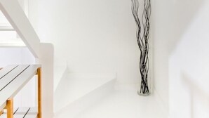 A staircase with a white railing, a framed photo on the wall, and a black abstract sculpture. - Begur Sunset ,2 bedroom loft close to the center of Begur. With terrace and gorgeous sea views (H42) (Begur)