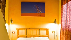 Un lit avec une tête de lit en bois, deux lampes de chevet et un tableau accroché au mur.