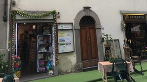 Un bâtiment doté de nombreuses fenêtres, dont certaines sont équipées de volets, et d’une devanture de magasin sur laquelle on peut lire l’inscription « Cartolena Boboli ».