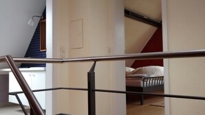 A bedroom with a bed, a window, and a staircase. - Franconian half-timbered house for 5 people (Krombach)