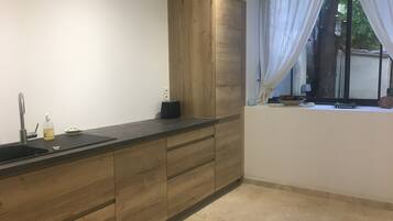 Een waterkoker, een blender, keukenpapier, een eettafel