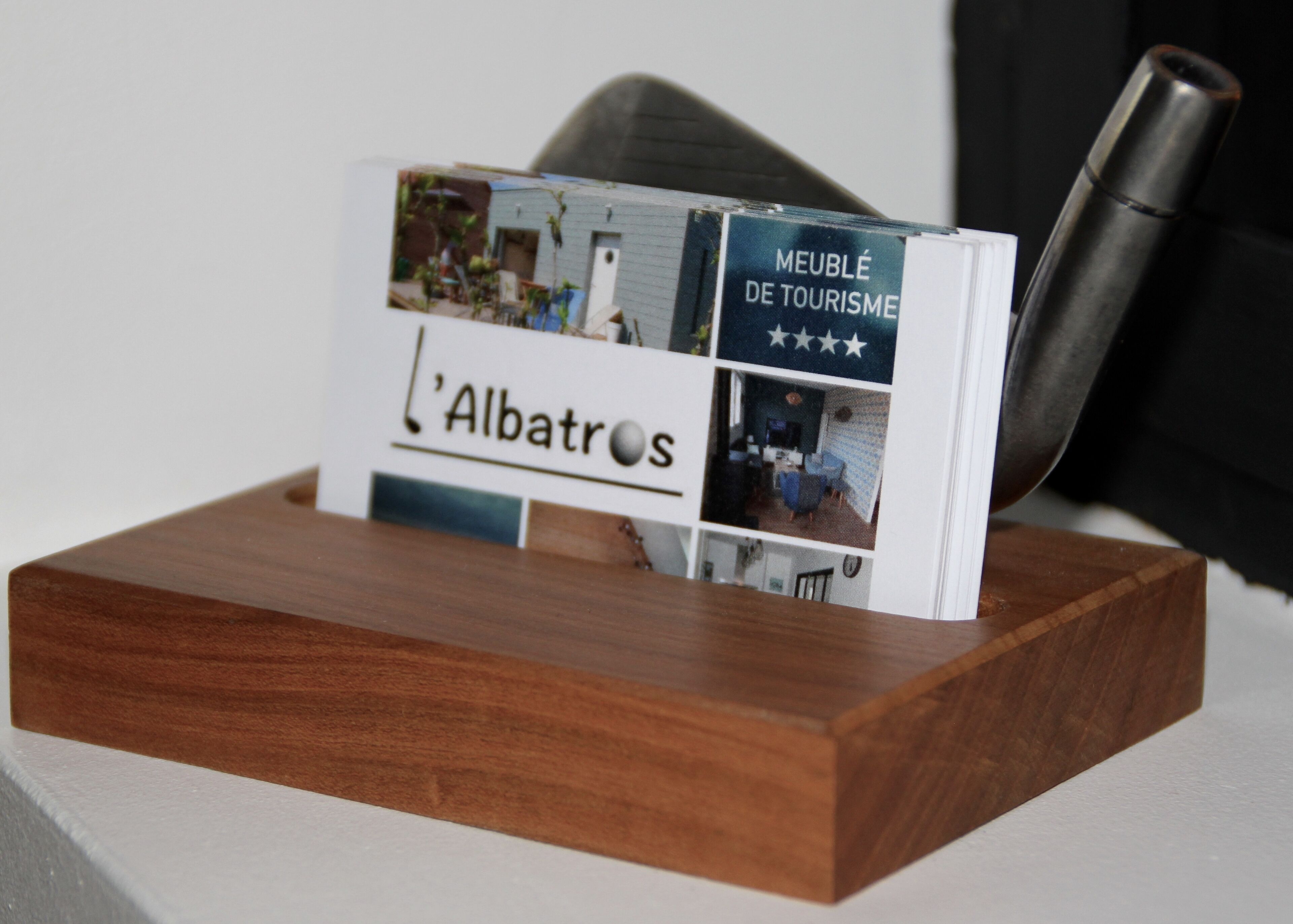 Un expositor de madera con un letrero que muestra 'L'Albatros' y 'Meublé de Tourisme', e imágenes de una habitación y una clasificación por estrellas.