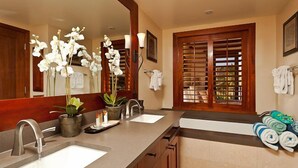 A bathroom with two sinks, a large mirror, and a window with wooden shutters. - Exceptional 5-stars Beach Villas at Ko Olina - 3 Bedrooms & 3 Full Bathrooms (Ko Olina)