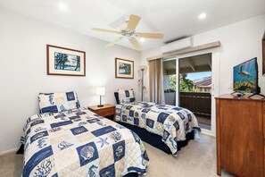 A bedroom with two beds, a ceiling fan, a TV, and a sliding glass door leading to a balcony. - Spacious 2BR/2BA Condo - Ocean View, Above it All, Oceanside Pool and 3 Zone A/C (Kailua-Kona)