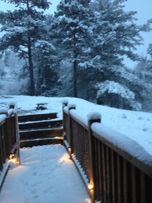 Stroll up the winding staircase, surrounded by snow-covered trees, to a serene winter wonderland.