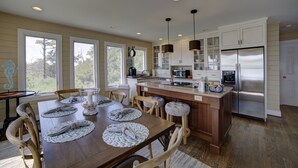 A modern kitchen with a central island, white cabinetry, and stainless steel appliances. - Relax, Refresh, Renew..Waterfront Cottage..Near Williamsburg (Gloucester)