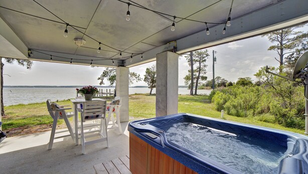 A covered outdoor area with a hot tub, seating, and a view of a lake. - Relax, Refresh, Renew..Waterfront Cottage..Near Williamsburg (Gloucester)