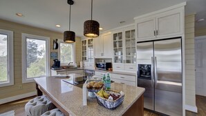 A modern kitchen with white cabinetry, a stainless steel refrigerator, and a granite countertop. - Relax, Refresh, Renew..Waterfront Cottage..Near Williamsburg (Gloucester)