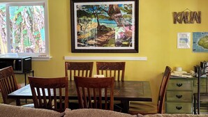 Uma sala de jantar com mesa, cadeiras e um quadro na parede.
