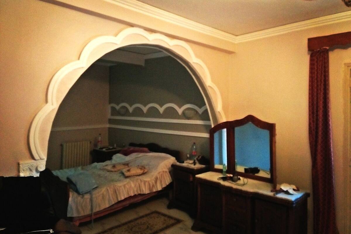 A bedroom with a bed, a dresser, and a mirror.
