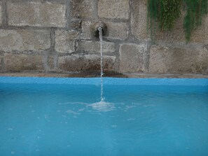 A stone wall with a water spout. - Casa do Abade - Solar de Goujoim (Armamar)