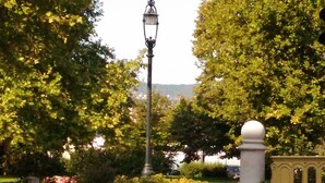 Una farola, un column blanco y una valla amarilla en un parque.