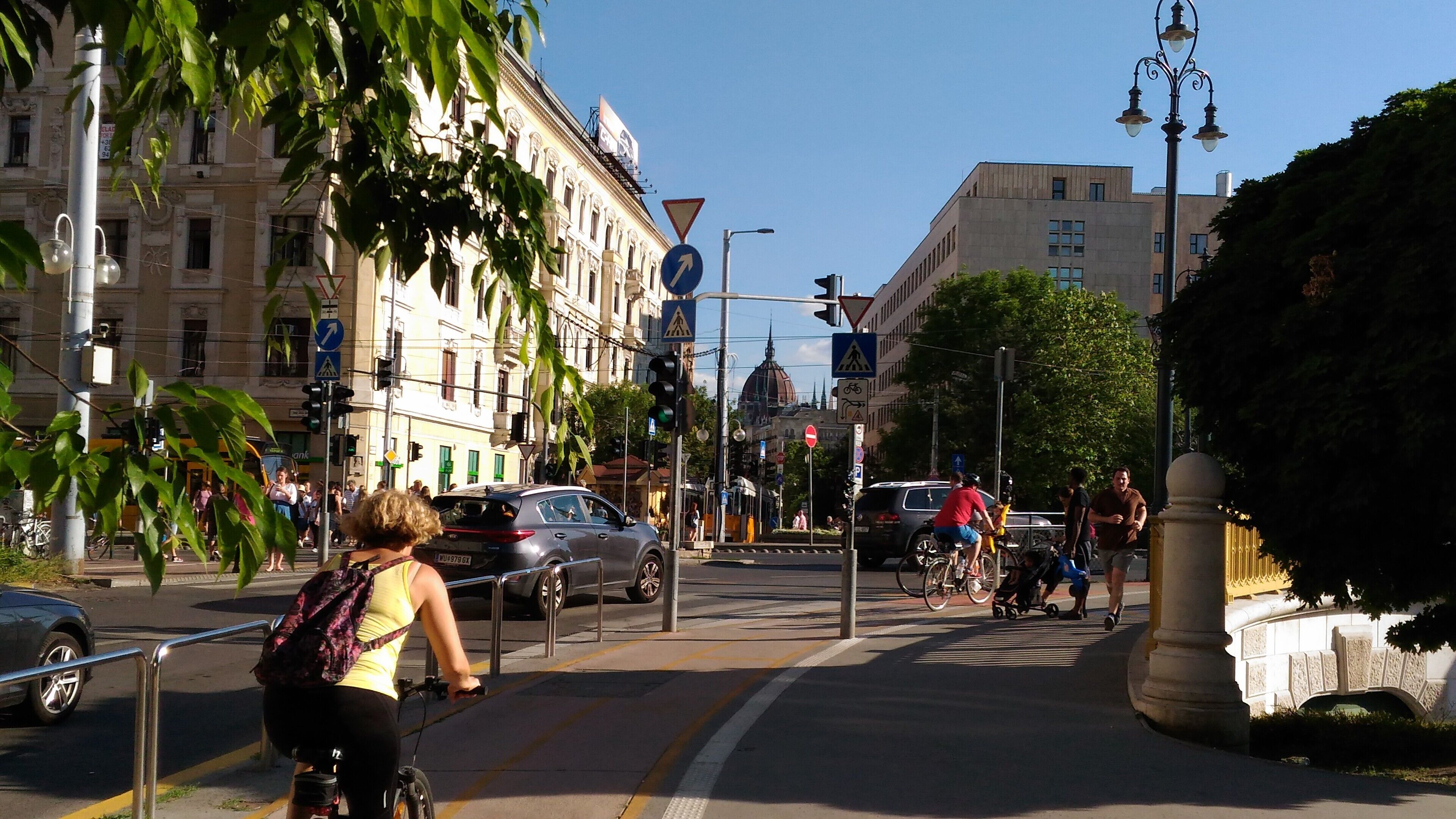 Een straatbeeld met voetgangers, fietsers en auto's.