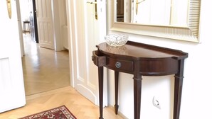 Un pasillo con una consola de madera, un cuenco de vidrio y un espejo.
