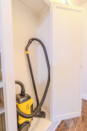 Ein Staubsauger in einem Zimmer mit weißen Wänden und Holzboden.