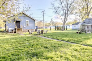 Un quartier résidentiel comprenant une maison, une table de pique-nique et une pelouse.