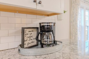 Una macchina per il caffè su un vassoio, con un cartello accanto.