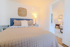Une chambre à coucher avec un grand lit, une table de chevet, une lampe et une horloge murale.