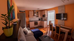 A compact living space with a kitchenette, a dining area, and a sofa. - Family & Freelance Apartment in the center of Ski Amadé (Altenmarkt im Pongau)