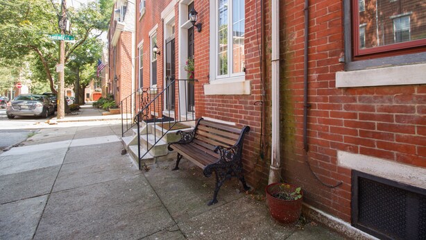 A red brick building with a bench outside. - Large + Comfortable! Great Location! Sleeps 9! (Philadelphia)