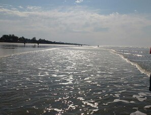 Une plage avec une eau calme et un ciel dégagé.