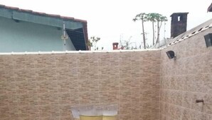 Una piscina con suelo de baldosas y un muro de ladrillo al fondo.
