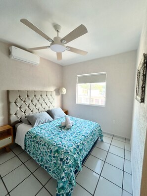 A bedroom with a bed, a ceiling fan, a window, and a wall-mounted air conditioner. - Loft Yexalem - 2 Bedrooms in Puerto Morelos, 7 Min to the Beach (Puerto Morelos)