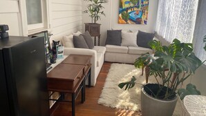 Una sala de estar moderna con un sofá, una mesa de centro, un televisor y una planta en maceta.