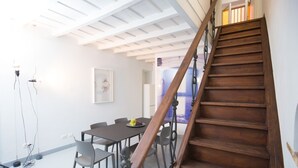 A dining area with a wooden staircase leading to an upper level.