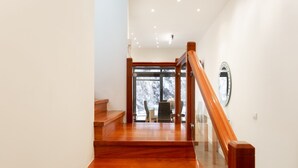 A wooden staircase leading to a glass door with a view of a snowy landscape. - Luxury villa with panoramic ocean view (Guía de Isora)