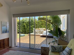 Um quarto espaçoso com uma grande porta de vidro deslizante que dá para um deck ao ar livre.