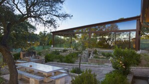 An outdoor patio with stone benches and a pergola structure. - Casa de Campo el Encinar - Paddleball, Pickleball, Swimming Pool and Barbecue (Santa Cruz del Retamar)
