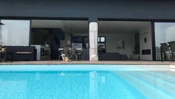 A modern house with a swimming pool, a dining area, and a living room. - Architect Villa with heated pool  (Séné)