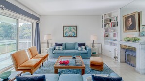 Una sala de estar moderna con un sofá, sillones, una mesa de centro y una chimenea.
