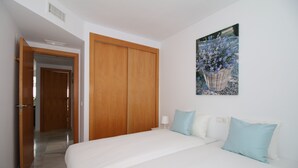 Ein Schlafzimmer mit einem großen Bett, einem Holzschrank und einem an der Wand befestigten Bild mit Blumen.