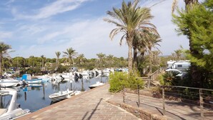 A marina with boats docked, palm trees, and a brick pathway. - Landelijk gelegen villa met privé zwembad, in het zuiden van Sardinië (Perdaxius)