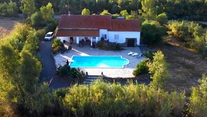 A house with a swimming pool surrounded by greenery and a mountainous backdrop. - Landelijk gelegen villa met privé zwembad, in het zuiden van Sardinië (Perdaxius)