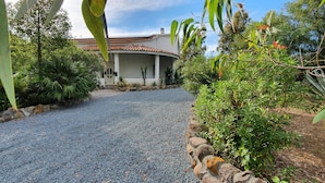 A house with a gravel driveway leading to a covered porch. - Landelijk gelegen villa met privé zwembad, in het zuiden van Sardinië (Perdaxius)